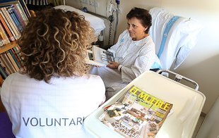 Imatge d'una voluntària de Biblioarreu amb una pacient del Trueta explicant-li com funciona el nou servei.